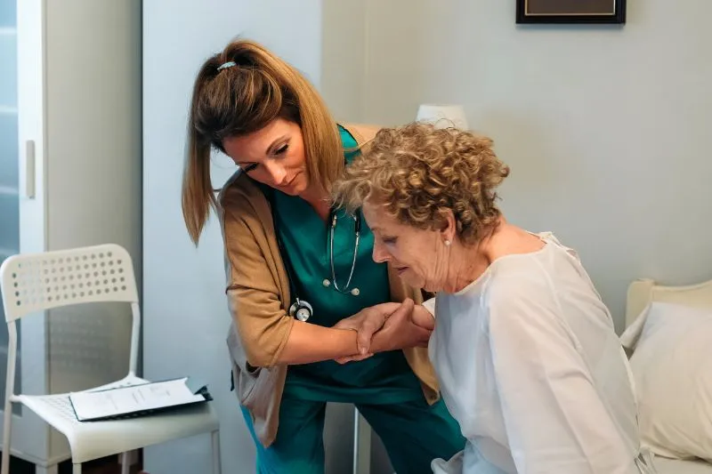 Carer helping an elderly person out of bed - Overnight Care