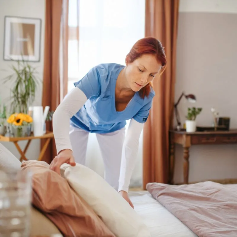 Caregiver making the bed at clients home